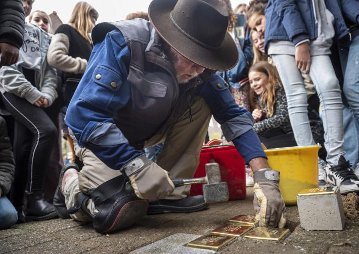 Kunstenaar Gunter Demnig plaatst de Stolpersteine voor de familie Levie in de Merelstraat in Breda.